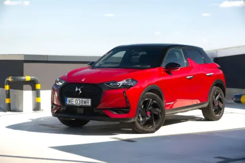 Czerwony DS3 Crossback z czarnym dachem na parkingu.