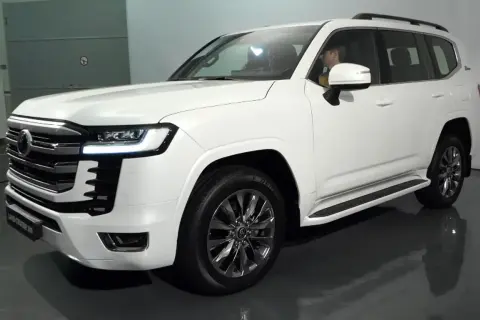 Biały Land Cruiser 300 z chromowanymi felgami i eleganckim grillem, gotowy na każdą przygodę.