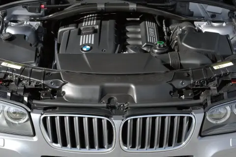 Silnik BMW X3 2005. Widok komory silnika z charakterystyczną atrapą chłodnicy i logo BMW.