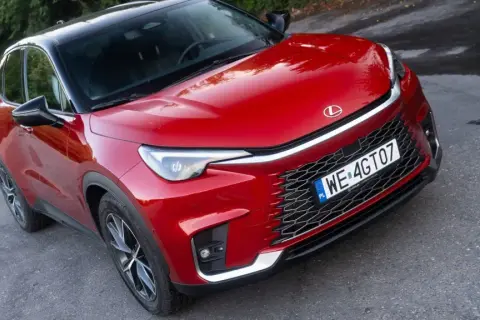 Czerwony Lexus LBX na drodze. Wiele osób szuka Lexus LBX opinie, by dowiedzieć się więcej o tym modelu.