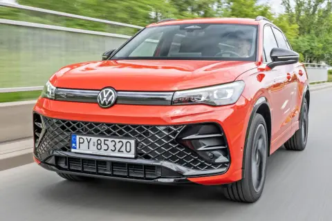 Pomarańczowy Volkswagen Tiguan w ruchu. Sprawdź aktualną volkswagen tiguan cena i dowiedz się więcej o tym stylowym SUV-ie.