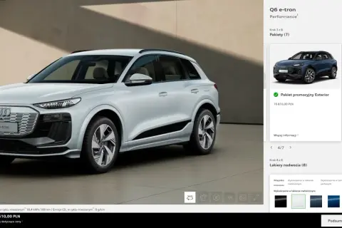 Białe Audi Q6 e-tron stoi na tle nowoczesnej architektury.