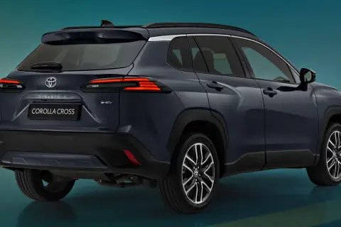 Ciemnogranatowy Toyota Corolla Cross Hybrid, widok z tyłu. Elegancki crossover z nowoczesnymi światłami LED i oznaczeniem "HEV".