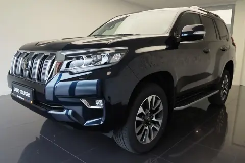 Ciemnogranatowy Land Cruiser Prado z chromowanym grillem i reflektorami LED, gotowy na każdą przygodę.