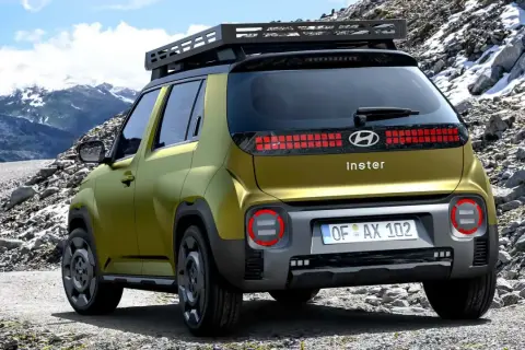 Złoty Hyundai Inster na górskiej drodze. Sprawdź hyundai inster cena i wybierz się na przygodę!