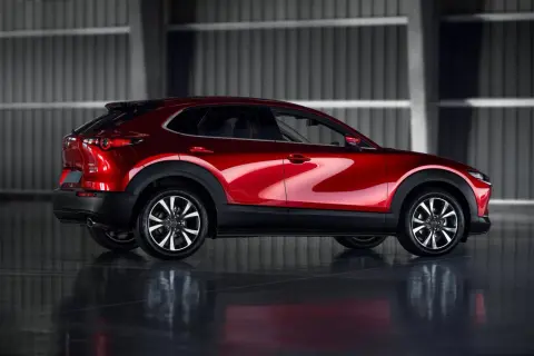 Błyszczący czerwony Mazda CX-30 z profilu. Poznaj jego kompaktowe mazda cx 30 wymiary, idealne do miasta.
