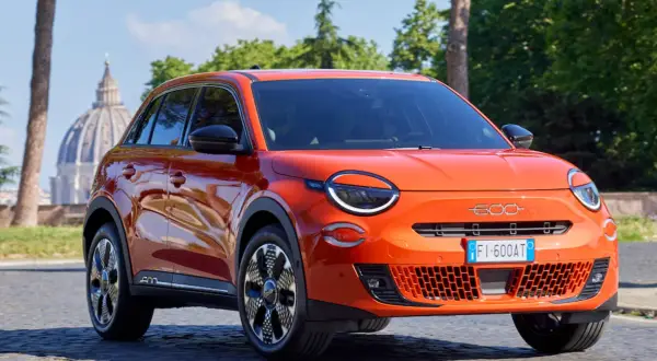 Pomarańczowy Fiat 600 na tle rzymskiej kopuły. Sprawdź atrakcyjną fiat 600 cena!