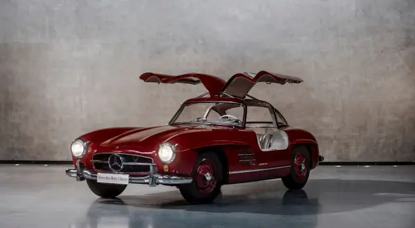 Czerwony Mercedes Gullwing z otwartymi drzwiami, ikona motoryzacji, prezentuje swoje klasyczne linie.