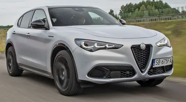Srebrny Alfa Romeo Stelvio w ruchu. Sprawdź aktualną alfa romeo stelvio cena i wybierz swój wymarzony SUV.
