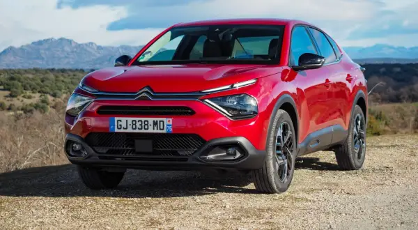 Czerwony Citroën C4X na tle górskiego krajobrazu.