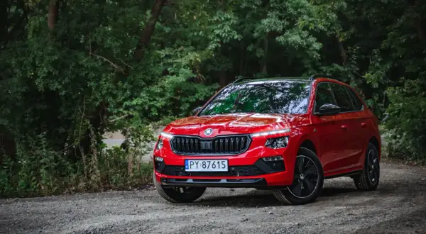 Czerwona Skoda Kamiq na leśnej drodze. Wiele osób szuka skoda kamiq opinie, by poznać ten model.
