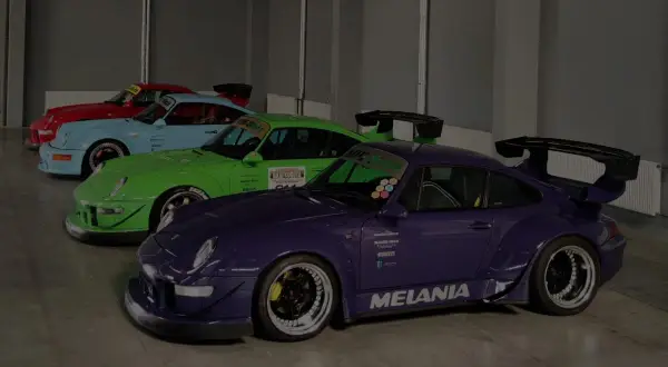 Kolekcja Porsche RWB w jaskrawych kolorach: fioletowy, zielony, błękitny i czerwony, z charakterystycznymi spojlerami i szerokimi nadkolami.