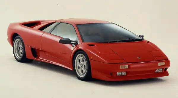 Czerwony Lamborghini Diablo, ikona lat 90., prezentuje swoje ostre linie i sportowy profil.