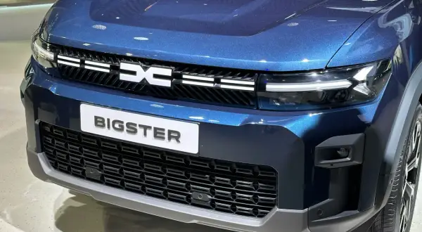 Niebieski Dacia Bigster z napisem "BIGSTER" i grillem z logo marki. Wyobraź sobie podróż tym autem na LPG!