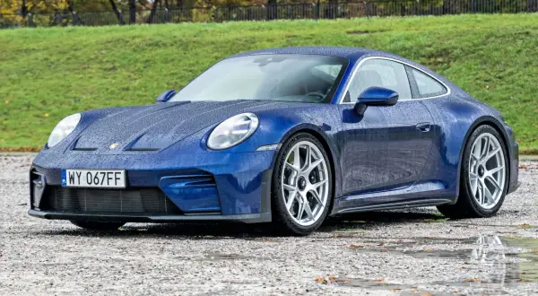 Niebieski Porsche 911 na mokrej nawierzchni. Zastanawiasz się nad porsche 911 cena?