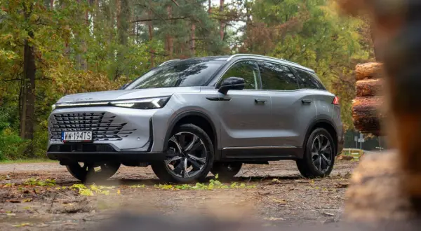 Srebrny SUV w lesie, gotowy na przygodę. Wiele osób chwali go w baic 7 opiniach za styl i osiągi.