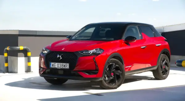 Czerwony DS3 Crossback z czarnym dachem na parkingu.