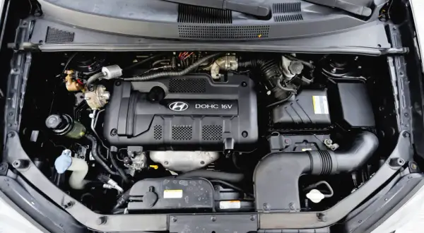 Silnik DOHC 16V w Hyundai Tucson 2007. Widoczny układ dolotowy i elementy osprzętu.
