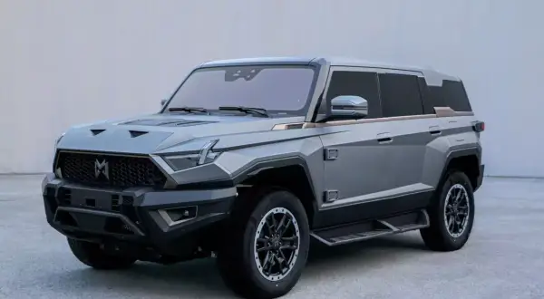 Szary mhero SUV o kanciastym designie, z masywnym grillem i ostrymi liniami.