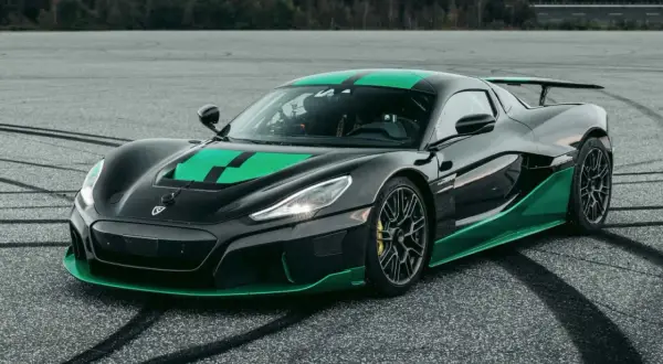 Czarny Rimac Nevera z zielonymi akcentami na masce i progach, gotowy do jazdy po torze.