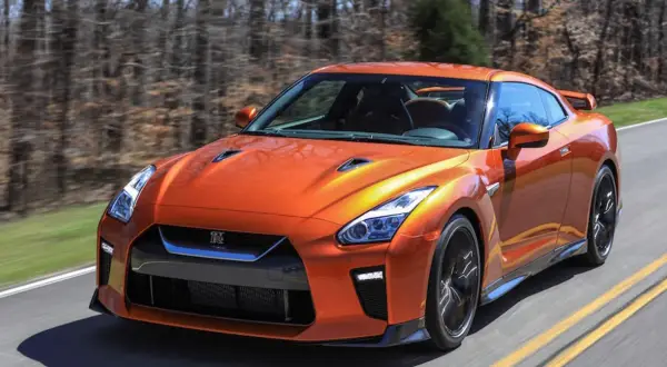 Pomarańczowy Nissan GT-R pędzi po drodze. Sprawdź aktualną nissan gtr cena i poczuj moc!