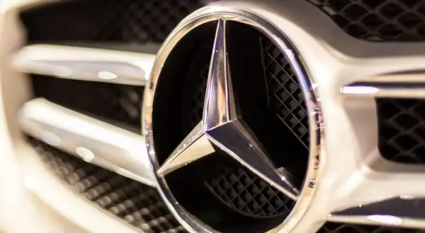 Błyszczące logo Mercedes na grillu, gotowe na przygodę w terenie. Ten mercedes 4x4 to symbol luksusu i mocy.