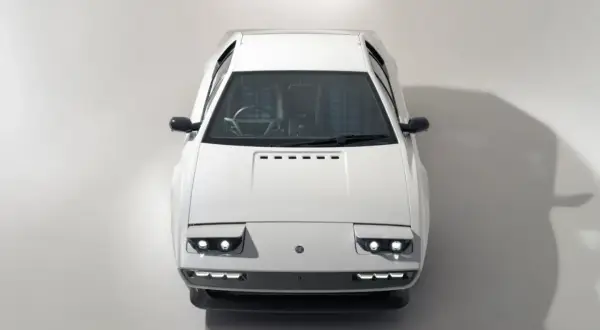 Biały Lotus Esprit z lat 70. z charakterystycznymi podnoszonymi światłami i kratkowaną tapicerką.
