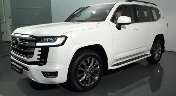 Biały Land Cruiser 300 z chromowanymi felgami i eleganckim grillem, gotowy na każdą przygodę.