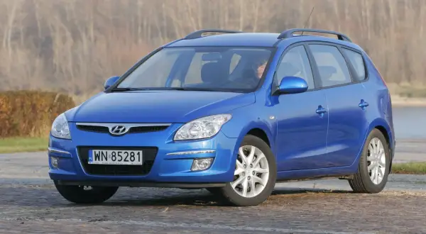 Niebieski Hyundai i30 1.6 benzyna na tle jesiennego krajobrazu.