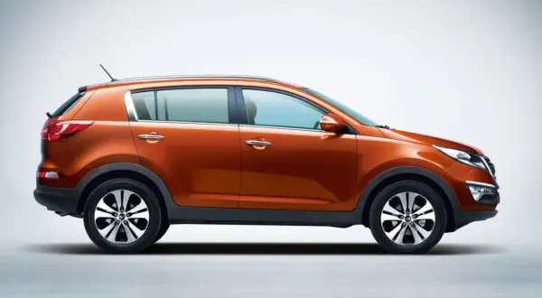 Pomarańczowy Kia Sportage 2015, widok z boku, na jasnym tle. Stylowy SUV gotowy na przygodę.