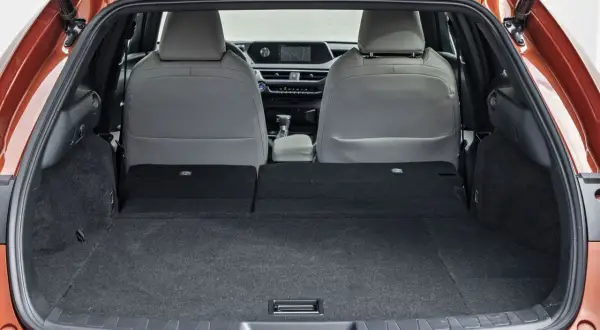 Widok bagażnika Lexusa UX z rozłożonymi tylnymi siedzeniami. Sprawdź lexus ux wymiary, by poznać jego pojemność.