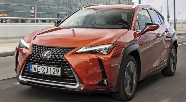 Pomarańczowy Lexus UX w ruchu, sprawdzam jego lexus ux cena.