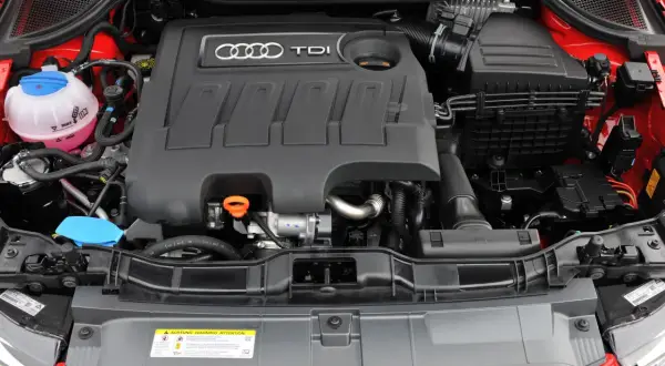 Silnik 1.6 TDI Audi z widocznym zbiorniczkiem płynu chłodniczego i osłoną silnika z logo TDI.