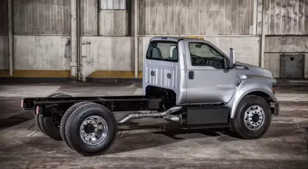 Srebrny Ford F650, gotowy do zabudowy, stoi w magazynie.