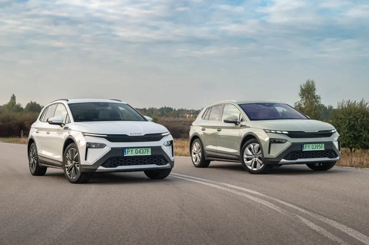 Dwa nowoczesne **Škoda SUV** na drodze: biały i zielony, z charakterystycznymi światłami i grillem.