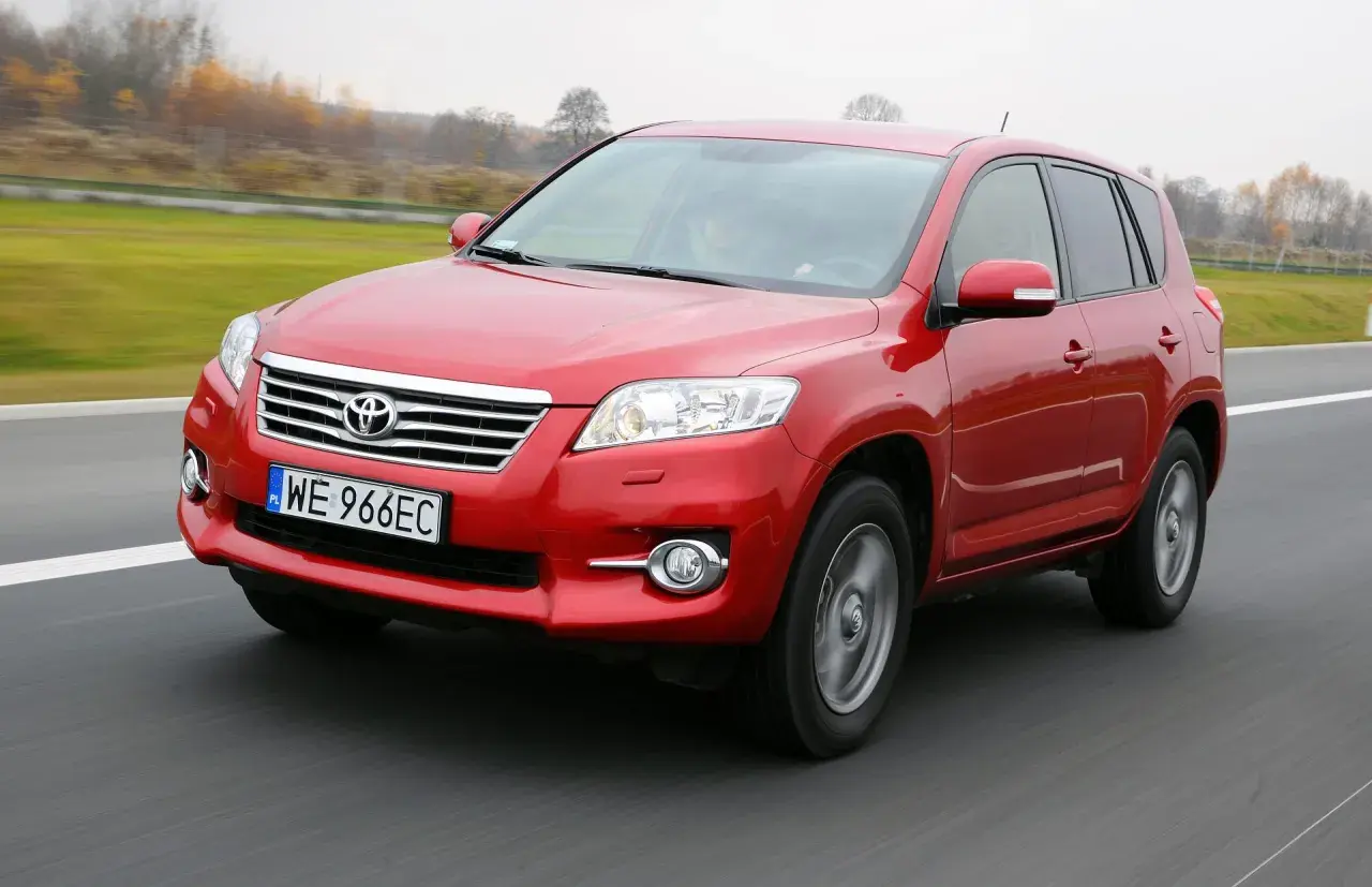 Czerwony SUV do 30 tys. na drodze, z widocznym numerem rejestracyjnym WE 966EC.
