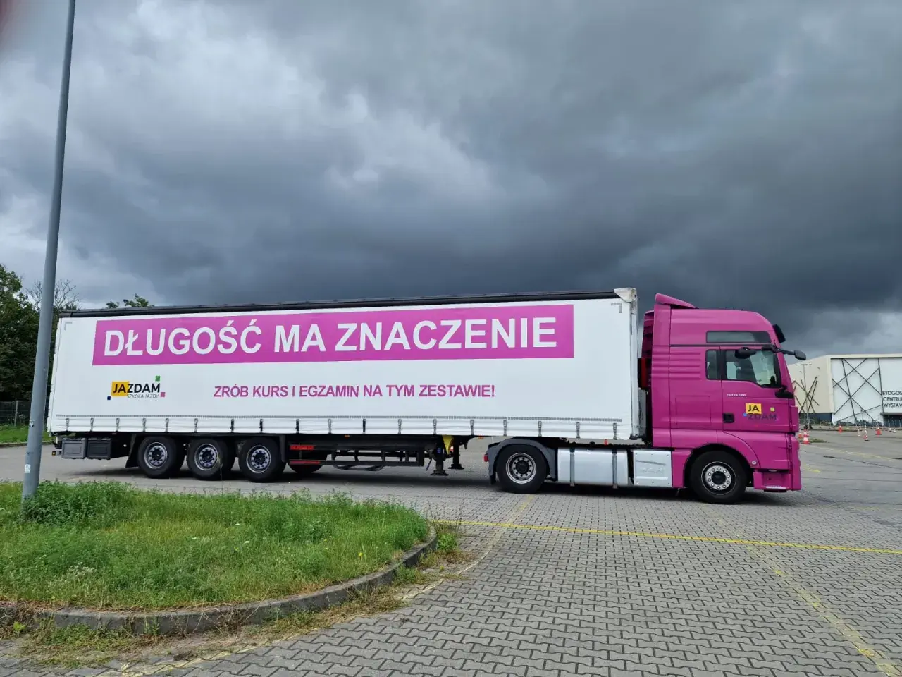 Różowa ciężarówka z napisem "Długość ma znaczenie. Zrób kurs i egzamin na tym zestawie!" zachęca do kwalifikacja wstępna przyspieszona.