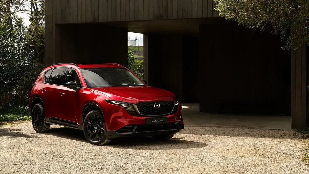 Czerwona Mazda CX-5 na żwirowym podjeździe. Sprawdź aktualną mazda cx-5 cena i wybierz swój wymarzony SUV.