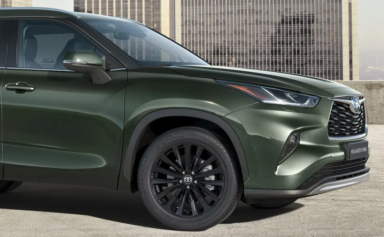 Elegancki, ciemnozielony Toyota Highlander 2025 z czarnymi felgami i nowoczesnym grillem, gotowy na miejskie wyzwania.