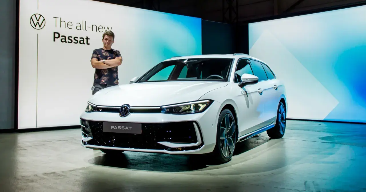 Mężczyzna stoi obok białego kombi, prezentując nowy Passat 2024.