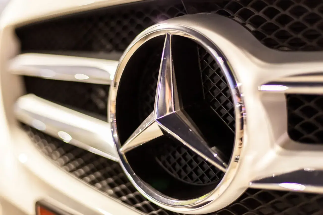 Błyszczące logo Mercedes na grillu, gotowe na przygodę w terenie. Ten mercedes 4x4 to symbol luksusu i mocy.