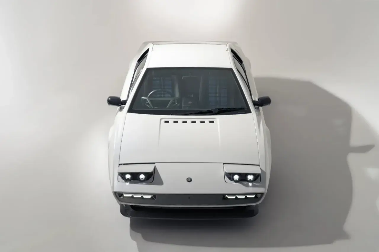 Biały Lotus Esprit z lat 70. z charakterystycznymi podnoszonymi światłami i kratkowaną tapicerką.