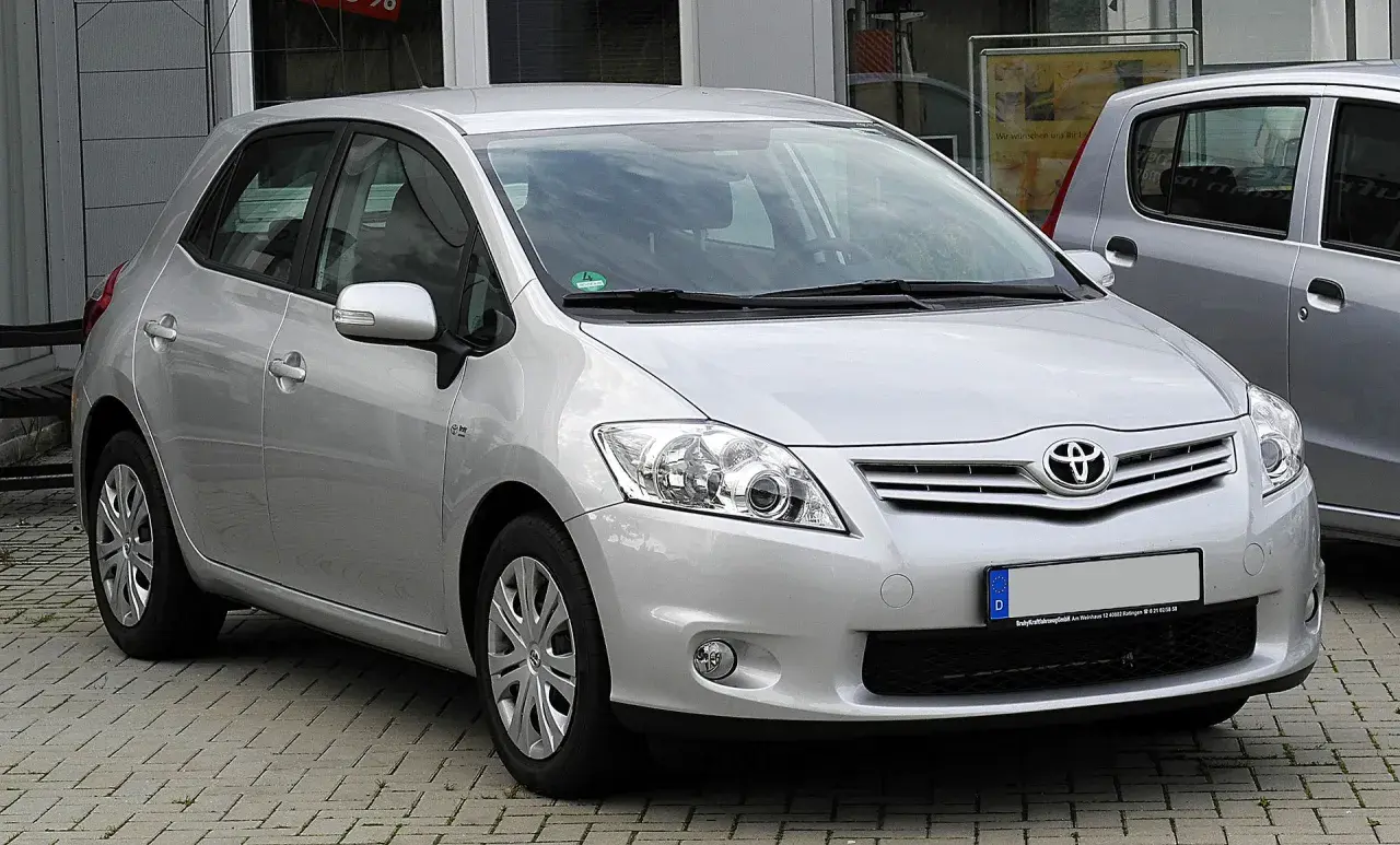 Srebrny Toyota Auris 1.6 benzyna zaparkowany na kostce brukowej.