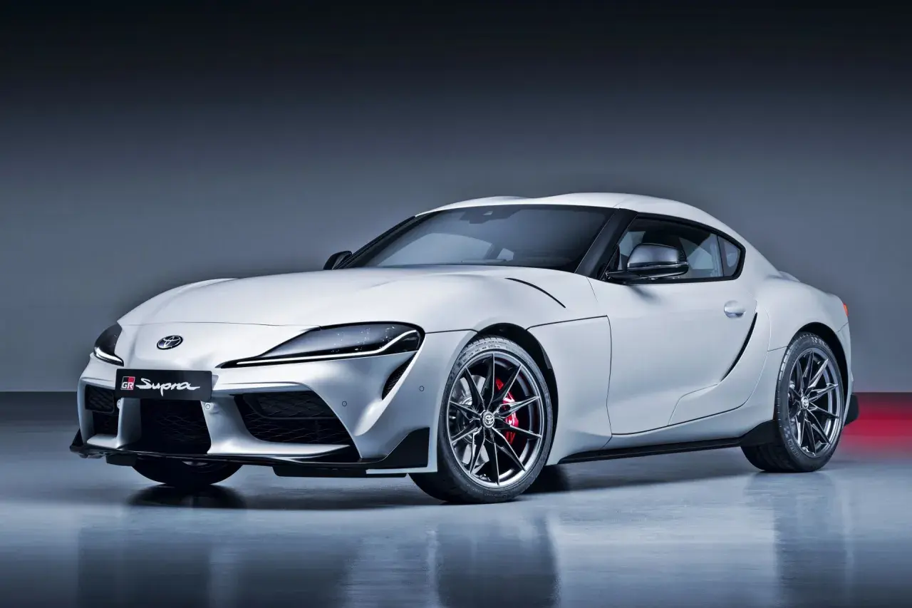 Biała Toyota GR Supra z czerwonymi zaciskami hamulcowymi i czarnymi felgami. Ta marka samochodu na zdjęciu to Toyota.