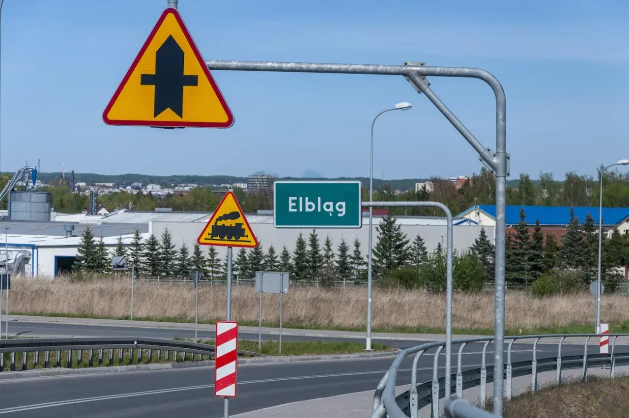 Znak ostrzegawczy "skrzyżowanie z drogą podporządkowaną" i przejazd kolejowy przed wjazdem do Elbląga.
