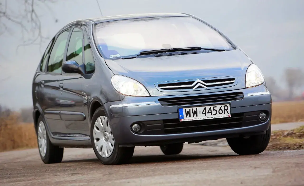 Szary Citroën Xsara Picasso z polskimi tablicami rejestracyjnymi WW 4456R jedzie po drodze.