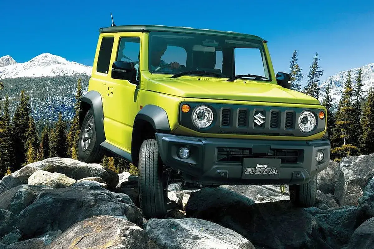 Żółty Suzuki Jimny 2026 pokonuje skalisty teren, gotowy na przygodę w górach.