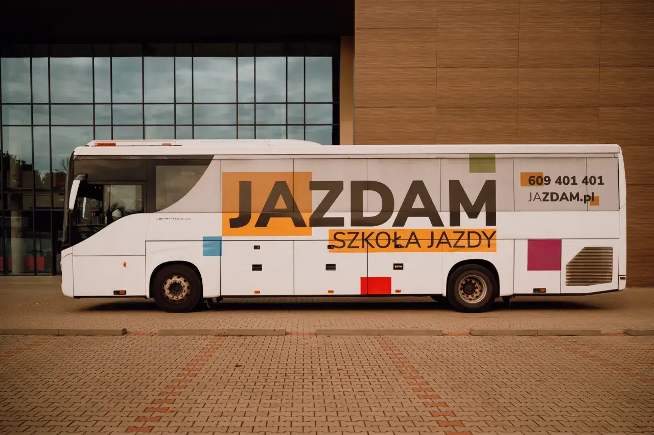 Biały autobus szkoleniowy z napisem 