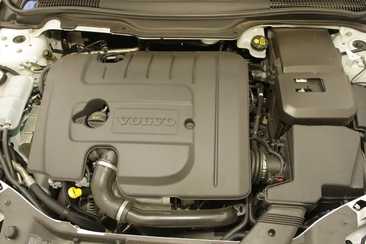 Silnik Volvo V50 1.6 diesel. Widoczna czarna osłona z logo Volvo, przewody i elementy układu dolotowego.