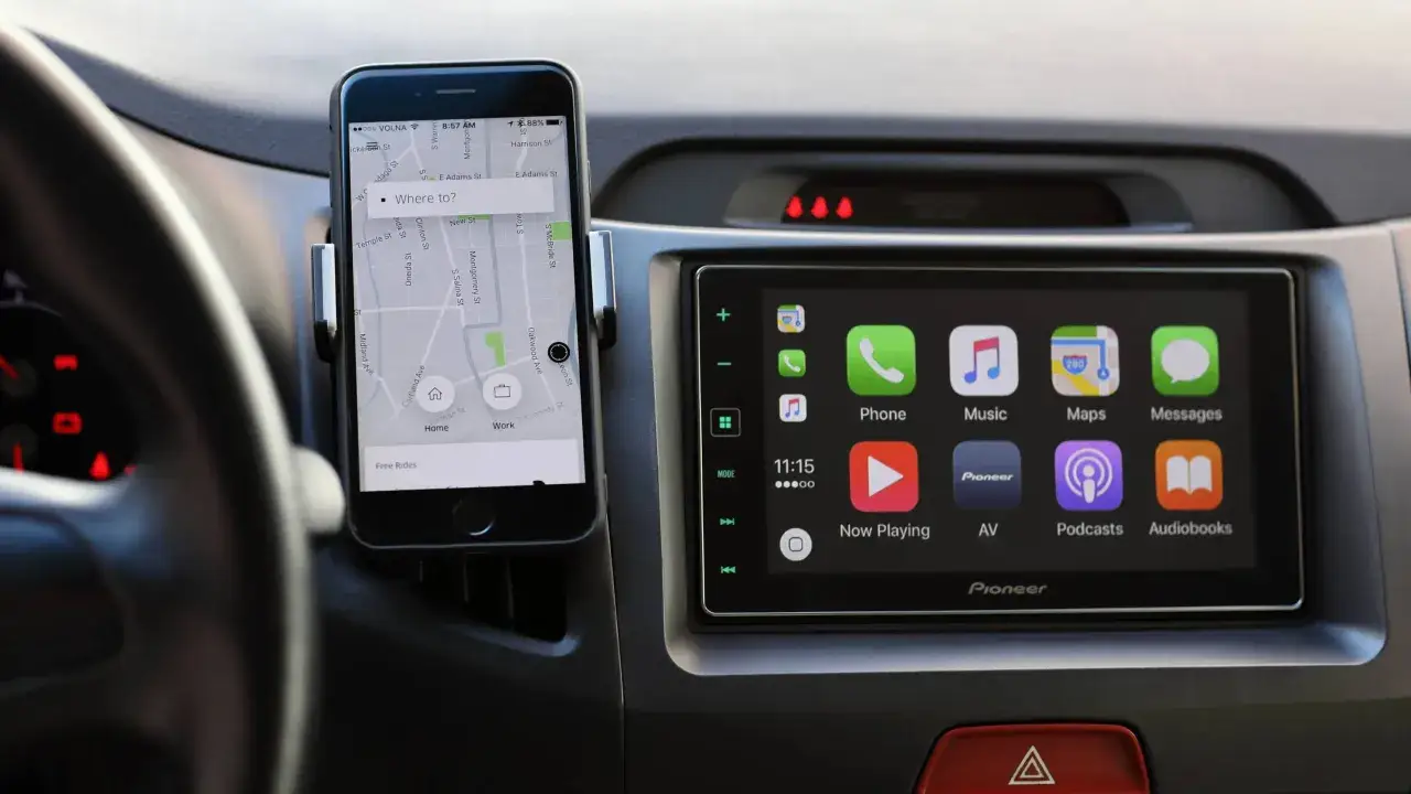 Telefon z nawigacją Uber i ekran Pioneer z Apple CarPlay, tworzące idealny mirror link do podróży.